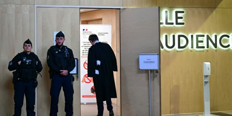 Des gendarmes et un avocat devant l'entrée de la salle d'audience à l'ouverture du procès en appel de l'attentat de Nice, le 22 avril 2024 à Paris